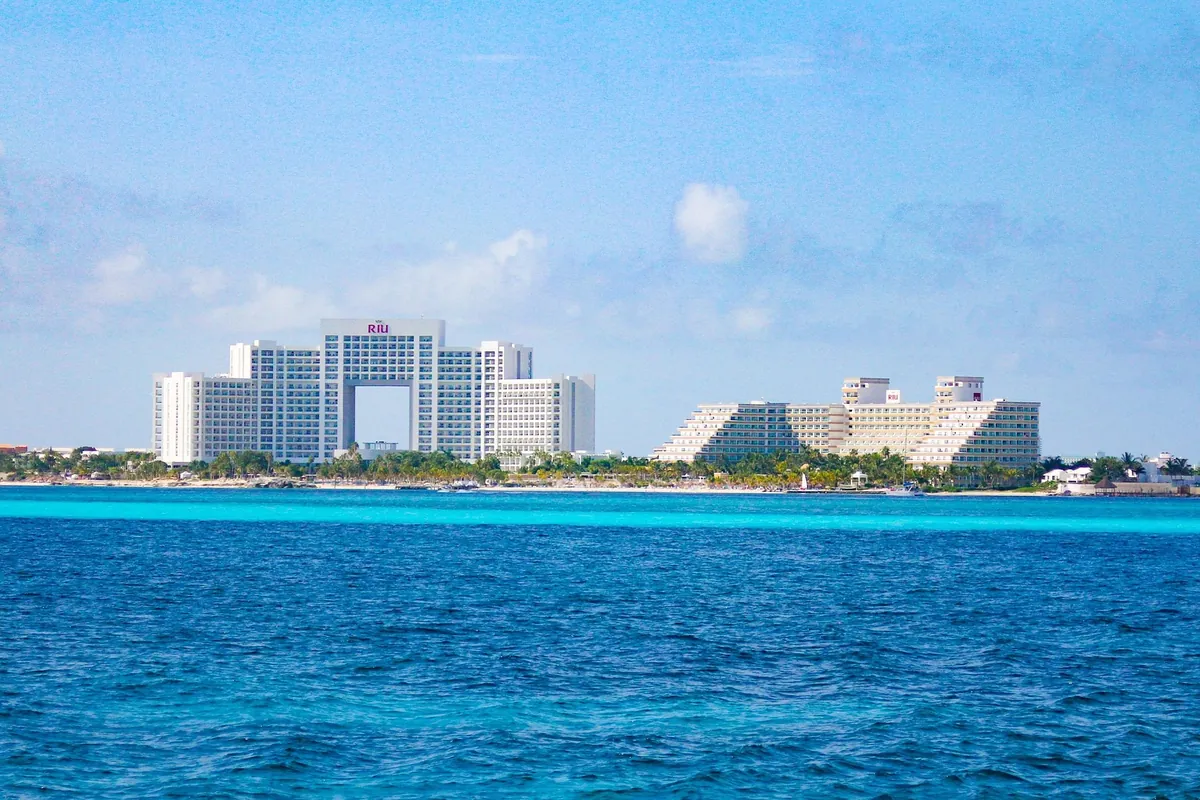Riu hotel towers viewed across turquoise water in the Cancun hotel zone