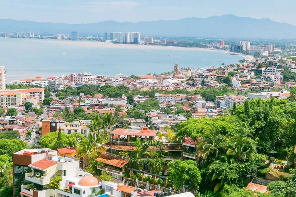 Aerial view of Puerto Vallarta's Banderas Bay coastline, with the old town's red-tile rooftops between the mountains and the water